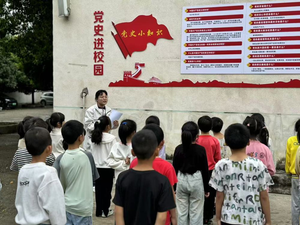 学生在文化墙前学习党史